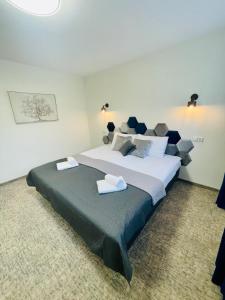 a bedroom with a large bed with two towels on it at Alanta Apartments Easy Kaunas in Kaunas