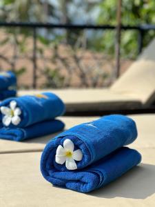 two blue towels with white flowers on top of a table at ORCHID LODGE SAMUI - Bed & Breakfast in Lamai