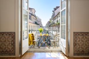 a balcony with a table and chairs on a city street at Residentas Arco do Bandeira in Lisbon