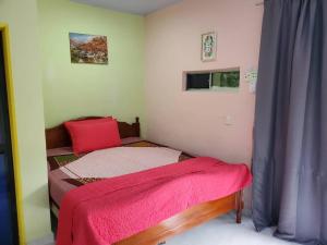 un pequeño dormitorio con una cama con una manta roja. en Inap Desa 3, 