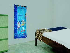 ein Schlafzimmer mit einem Bett und einer blauen Wand in der Unterkunft SPOT ON 92301 Penginapan Indola 
