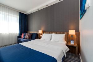 una camera d'albergo con letto e divano di Holiday Inn Express Bremen Airport, an IHG Hotel a Brema