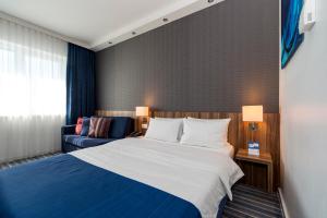 a hotel room with a bed and a couch at Holiday Inn Express Bremen Airport by IHG in Bremen