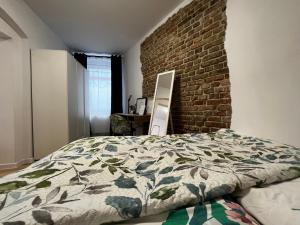 ein Schlafzimmer mit einem Bett und einer Ziegelwand in der Unterkunft Comfortable apartment for 1-4 guests in Chorzów