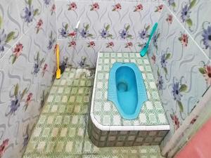 ein Badezimmer mit einem blauen WC auf dem Boden in der Unterkunft SPOT ON 92301 Penginapan Indola 