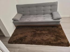 un sofá sentado en una sala de estar con una alfombra marrón en Apartamento Premium em Pinheiros, en São Paulo