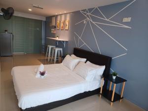 a bedroom with a large bed with white sheets at SY Staycation - Studio with Netflix in Bayan Lepas