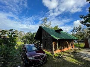 un'auto parcheggiata di fronte a una piccola casa di Cabaña para vacacionar río Sarapiqui a Sarapiquí