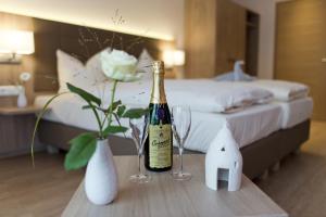una bottiglia di champagne su un tavolo in una camera da letto di Landhotel im Klostereck Strubel-Roos a Flonheim