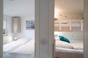 1 Schlafzimmer mit 2 Betten und 1 Etagenbett in der Unterkunft Ferienhaus "Möwennest" in Scharbeutz