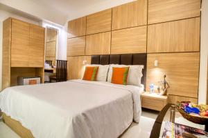 a bedroom with a large white bed with wooden walls at Roland Hotel in Kolkata