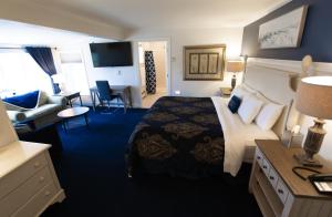 Habitación de hotel con cama grande y sala de estar. en Inn at Taughannock Falls, en Ithaca
