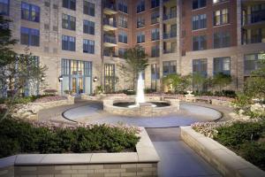 a courtyard with a fountain in front of a building at Fantastic 2 BR Condo At Pentagon CIty with Pool&Gym in Arlington