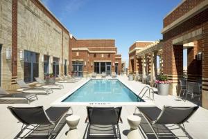 una piscina en un patio con sillas en Fantastic 2 BR Condo At Pentagon CIty with Pool&Gym en Arlington