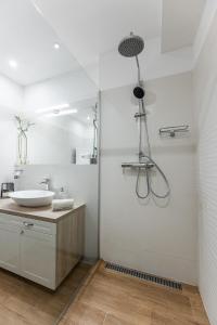 a white bathroom with a sink and a shower at New Spacious Apartment with City View in Košice