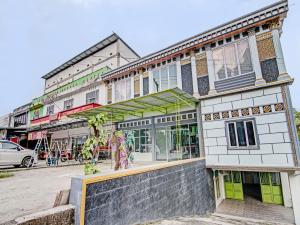 un bâtiment avec des portes et des fenêtres vertes dans une rue dans l'établissement OYO 92302 Salsa Homestay Syariah, à Bangkinang