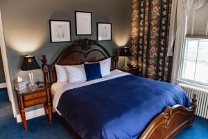a bedroom with a large bed with a blue blanket at Inn at Taughannock Falls in Ithaca