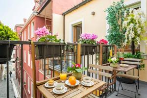 - un balcon avec une table, des chaises et des fleurs dans l'établissement Hinc Domus - Residenza Da Qui - Venezia Historical city center, à Venise