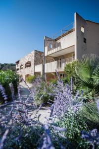 a building with purple flowers in front of it at Villages Clubs du Soleil - LE REVERDI in Grimaud