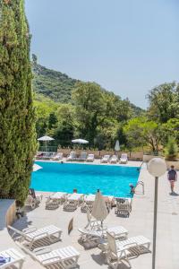 - une piscine avec des chaises longues et un bouquet de chaussons dans l'établissement Villages Clubs du Soleil - LE REVERDI, à Grimaud