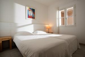 a white bed in a bedroom with a window at Villages Clubs du Soleil - LE REVERDI in Grimaud