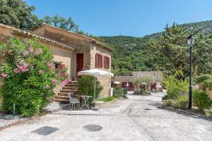 a building with a table and an umbrella in a courtyard at Villages Clubs du Soleil - LE REVERDI in Plan-de-la-Tour