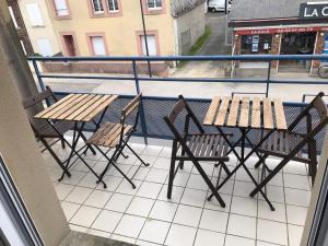 une table et des chaises assises sur un balcon dans l'établissement Saint Martin Appartement Duplex Proximité Immédiate Mer & Commerces, à Bréhal