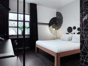 a bedroom with a white bed and a window at Mabi City Centre Hotel in Maastricht