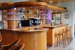 a bar in a restaurant with chairs around it at Hôtel Saint-Marc in Ploërmel