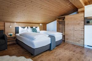 1 Schlafzimmer mit 2 Betten und Holzdecke in der Unterkunft Active Apartments in Maria Alm am Steinernen Meer
