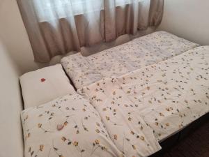 ein Bett mit einer Daunendecke mit Schmetterlingen drauf in der Unterkunft Departure Apartment in Sarajevo