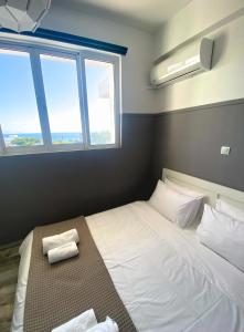 a bedroom with a bed with two towels on it at EMVI APARTMENTS III seaview near airport in Artemida