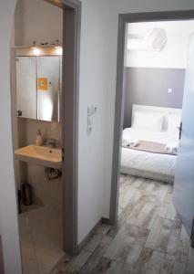 EMVI APARTMENTS III seaview near airport في أرتيميدا: حمام مع حوض وسرير