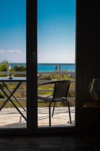 a view of the ocean from a door at EMVI APARTMENTS III seaview near airport in Artemida +27 photos