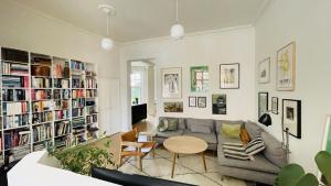 a living room with a couch and a table and bookshelves at ApartmentInCopenhagen Apartment 1439 in Hellerup