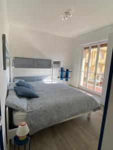 una camera da letto con un grande letto con cuscini blu di Loano: Centro e Mare a portata di mano a Loano