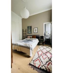 a bedroom with a bed and a rug at ApartmentInCopenhagen Apartment 1439 in Hellerup