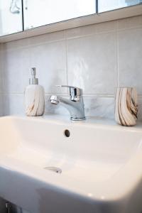 - un lavabo avec un robinet et 2 savons dans l'établissement EMVI APARTMENTS III seaview near airport, à Artemi