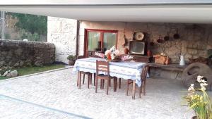d'une terrasse avec une table, des chaises et une télévision. dans l'établissement Casa de Santa Luzia, à Vila Praia de Âncora
