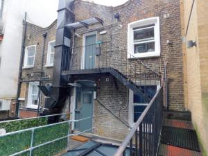 um edifício de tijolos com uma escada que leva a uma porta em Special Offer! Lovely studio - ZONE 1 - Hyde Park em Londres