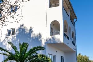 ein weißes Gebäude mit einer Palme davor in der Unterkunft Villa Ocean Breeze in Avliótai