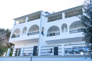 a white building with balconies and tables at Villa Ocean Breeze in Avliótai