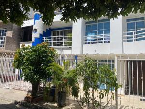 a white and blue building with trees in front of it at Hospedaje él Familia in Cartagena de Indias