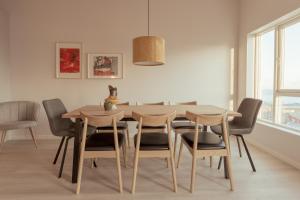 a dining room with a wooden table and chairs at New Aparthotel / Panoramic sea view in Tórshavn