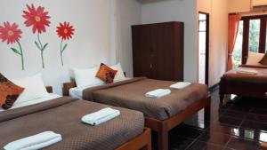 um quarto com duas camas com toalhas em LUCKY PAI Resort&Hostel em Pai