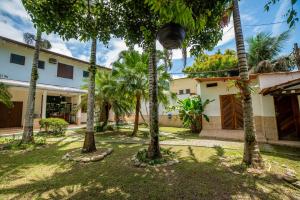 une cour avec des palmiers en face d'une maison dans l'établissement Pousada Cantinho do Sossego Paraty, à Parati