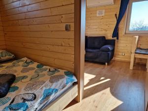 sypialnia z łóżkiem w drewnianym domku w obiekcie Apartament z Tężnią Solankową, Sauną, Kominkiem LED i Śniadaniem nad Jeziorem Żywieckim w mieście Zarzecze