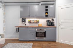 a kitchen with stainless steel appliances and white cabinets at Romantic studio apartment - private entrance! in Pärnu