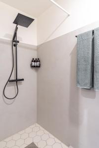 a white bathroom with a shower and a sink at Romantic studio apartment - private entrance! in Pärnu