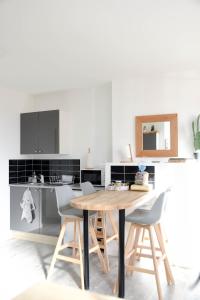 a kitchen with a wooden table and chairs at residence romi maison aeroport tillé in Tillé
